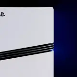 Biała konsola PlayStation 5 leży poziomo, z niebieskim światłem emanującym z bocznego otworu wentylacyjnego.