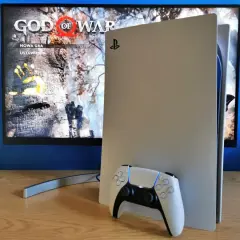 Konsola PlayStation 5 z kontrolerem DualSense obok. Na ekranie widoczny tytuł gry "God of War" i opcje "Nowa gra", "Ustawienia". Idealny moment na playstation aktualizacja.