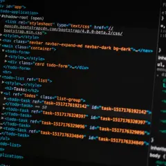 Kod HTML i CSS na ekranie komputera. Pokazuje fragmenty kodu, które można wykorzystać, aby nauczyć się, jak zrobić stronę HTML w notatniku.
