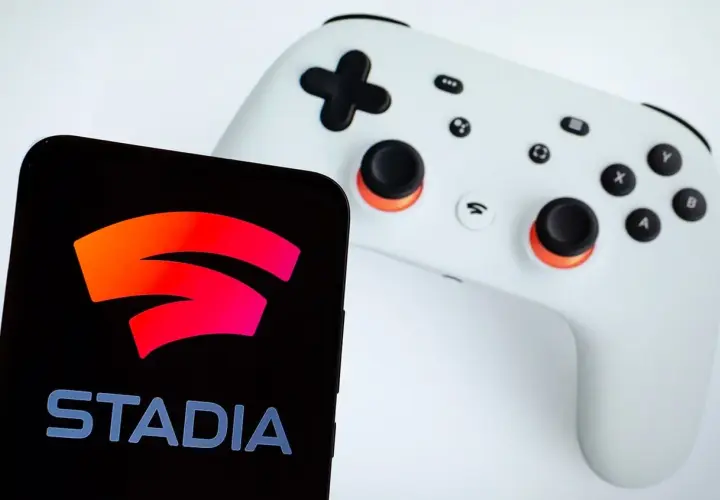 Smartfon z logo Google Stadia obok białego kontrolera. Gotowy do gry!