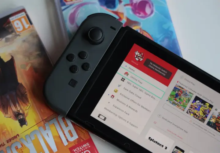 Nintendo Switch z grami, w tym Splatoon 3. Na ekranie widoczne menu z opcjami, jak "Online Play" i "Save Data Cloud", sugerujące datę premiery i funkcje konsoli.