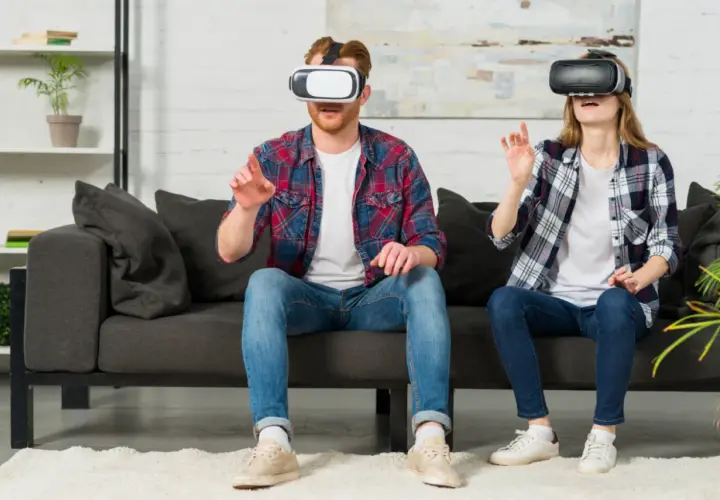 Para dowiedzieć się, jak oglądać filmy VR na PS4, zobacz parę w goglach VR na kanapie, zanurzoną w wirtualnym świecie.