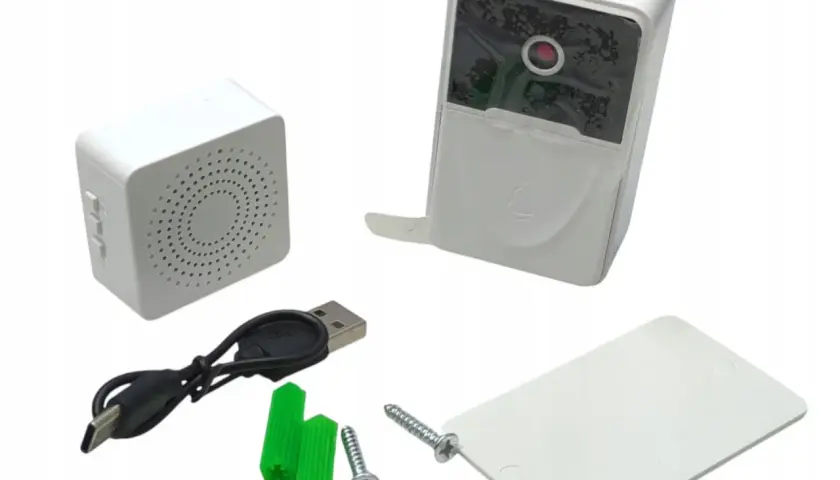 Zestaw do domofonu w bloku: moduł zewnętrzny z kamerą i dzwonkiem, moduł wewnętrzny z głośnikiem, kabel USB, kołki i śruby.
