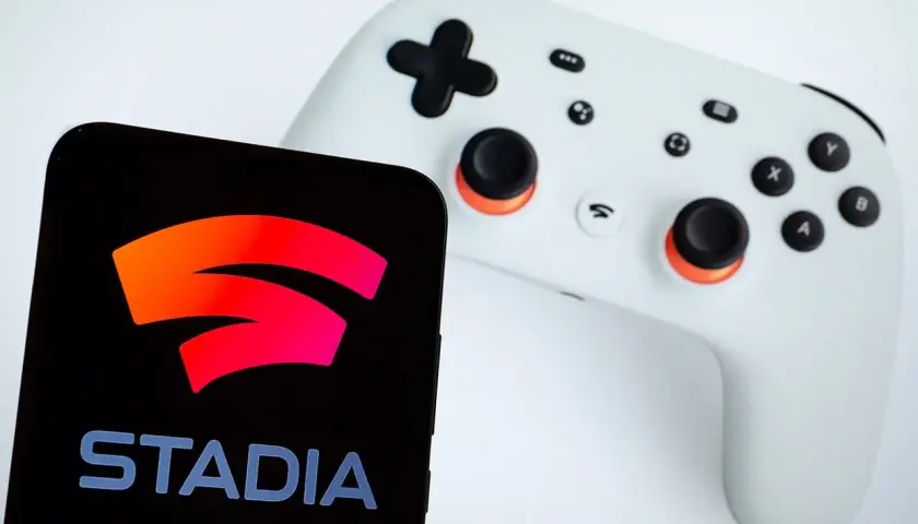 Smartfon z logo Google Stadia obok białego kontrolera. Gotowy do gry!