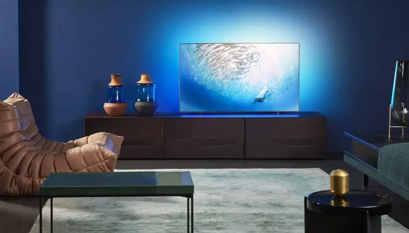 Nowoczesny salon z telewizorem wyświetlającym podwodny świat. To pokazuje, co to jest sztuczna inteligencja w telewizorze – inteligentne dopasowanie obrazu do otoczenia.