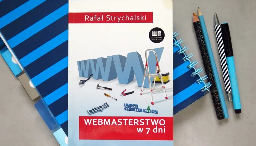 Książka "Webmasterstwo w 7 dni" Rafała Strychalskiego, która pokazuje, jak zrobić dobrą stronę html. Narzędzia i notatniki obok.