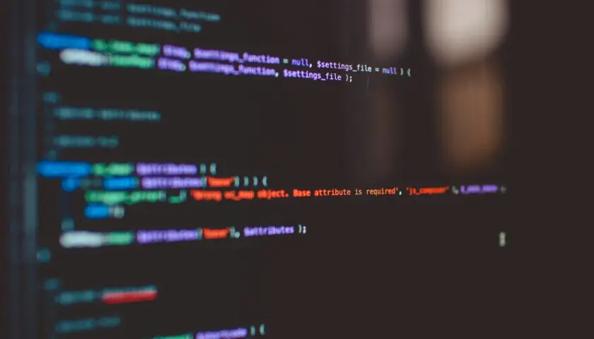 Fragment kodu z kolorowym podświetleniem, pokazujący jak podłączyć CSS do HTML. Widoczne fragmenty kodu PHP i JavaScript.