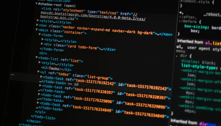 Kod HTML i CSS na ekranie komputera. Pokazuje fragmenty kodu, które można wykorzystać, aby nauczyć się, jak zrobić stronę HTML w notatniku.