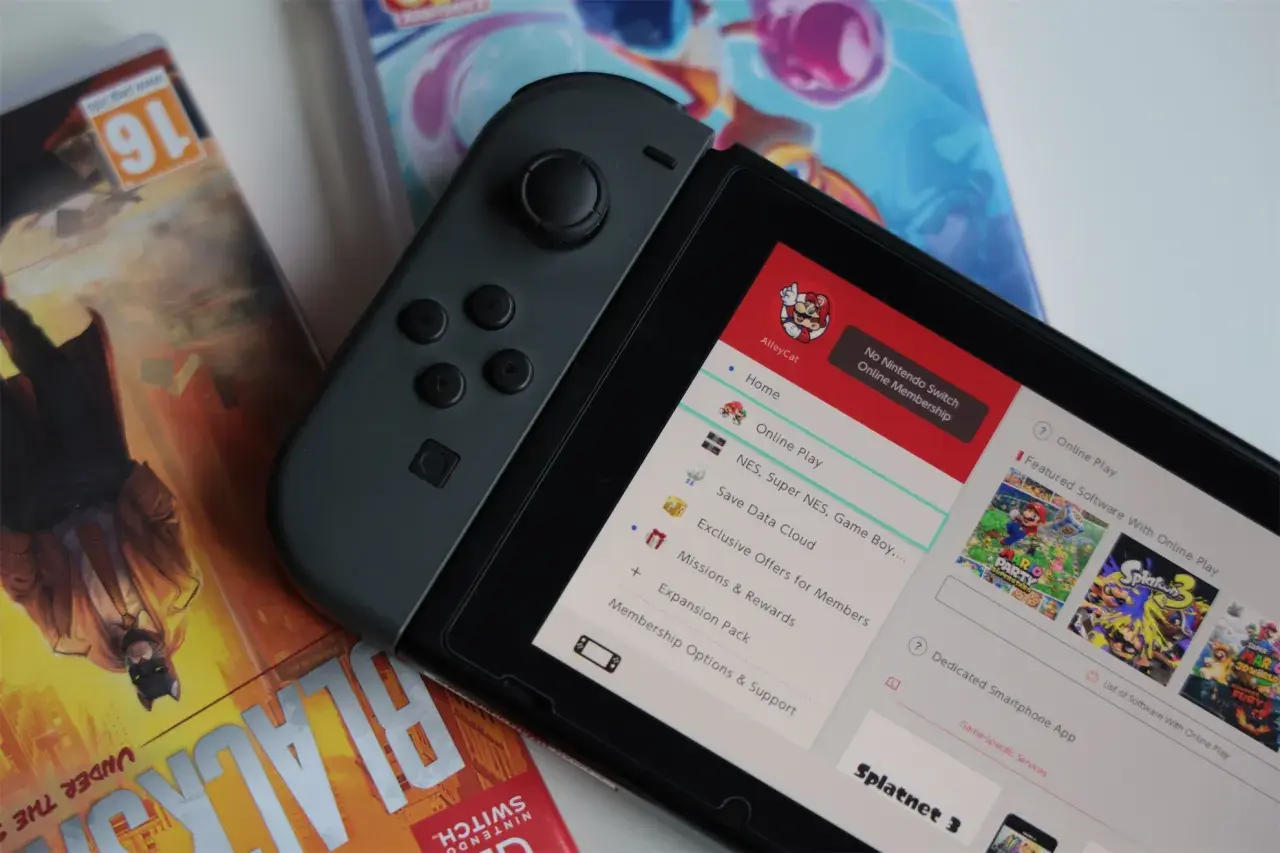 Nintendo Switch z grami, w tym Splatoon 3. Na ekranie widoczne menu z opcjami, jak "Online Play" i "Save Data Cloud", sugerujące datę premiery i funkcje konsoli.