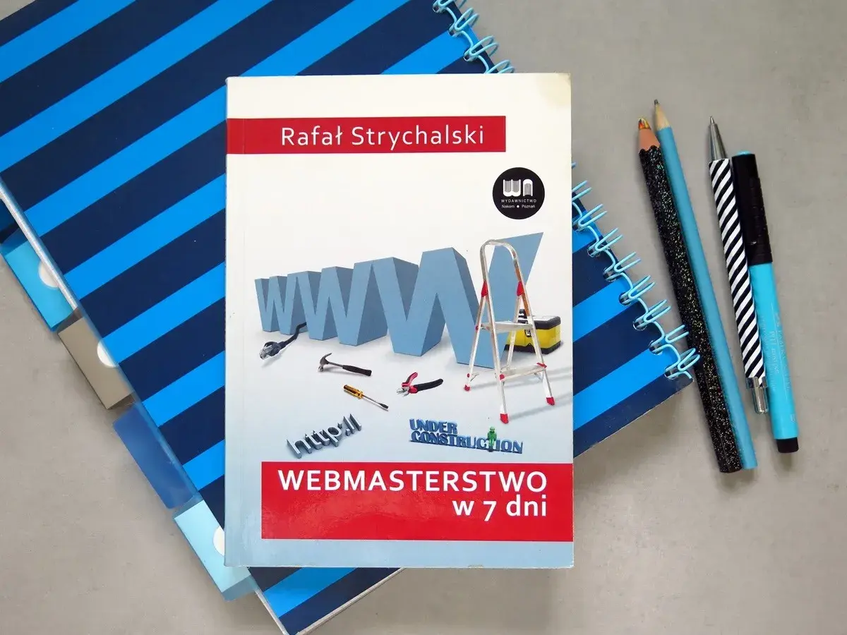 Książka "Webmasterstwo w 7 dni" Rafała Strychalskiego, która pokazuje, jak zrobić dobrą stronę html. Narzędzia i notatniki obok.