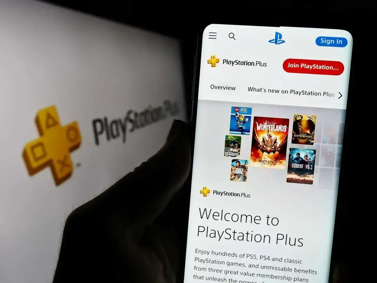 Telefon wyświetla stronę PlayStation Plus z grami. Odkryj setki **playstation extra gry** i ciesz się unikalnymi korzyściami.