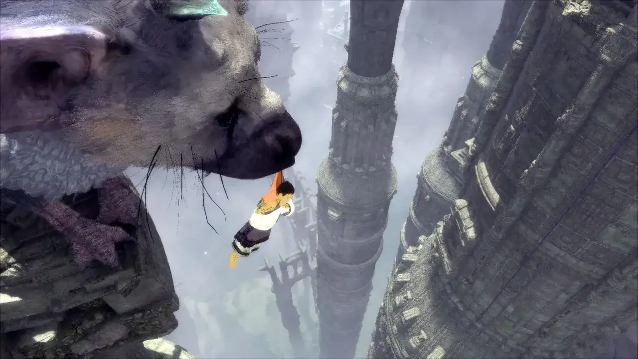 Chłopiec trzyma się pyska wielkiego stworzenia, wisząc nad przepaścią między starożytnymi wieżami. The Last Guardian PC.