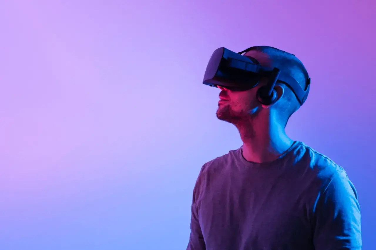 Mężczyzna w goglach VR, gotowy do zanurzenia się w wirtualnym świecie. Dowiedz się, jak oglądać filmy VR na PS4.